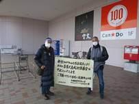 イトーヨーカ堂前で盲導犬育成応援募金活動中止のお知らせの看板を持っている渋谷と国井の写真が掲載されています。